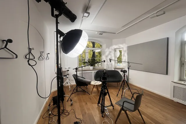 Aufgebautes Interview-Set mit Studiolicht, Kameras und zwei Stühlen